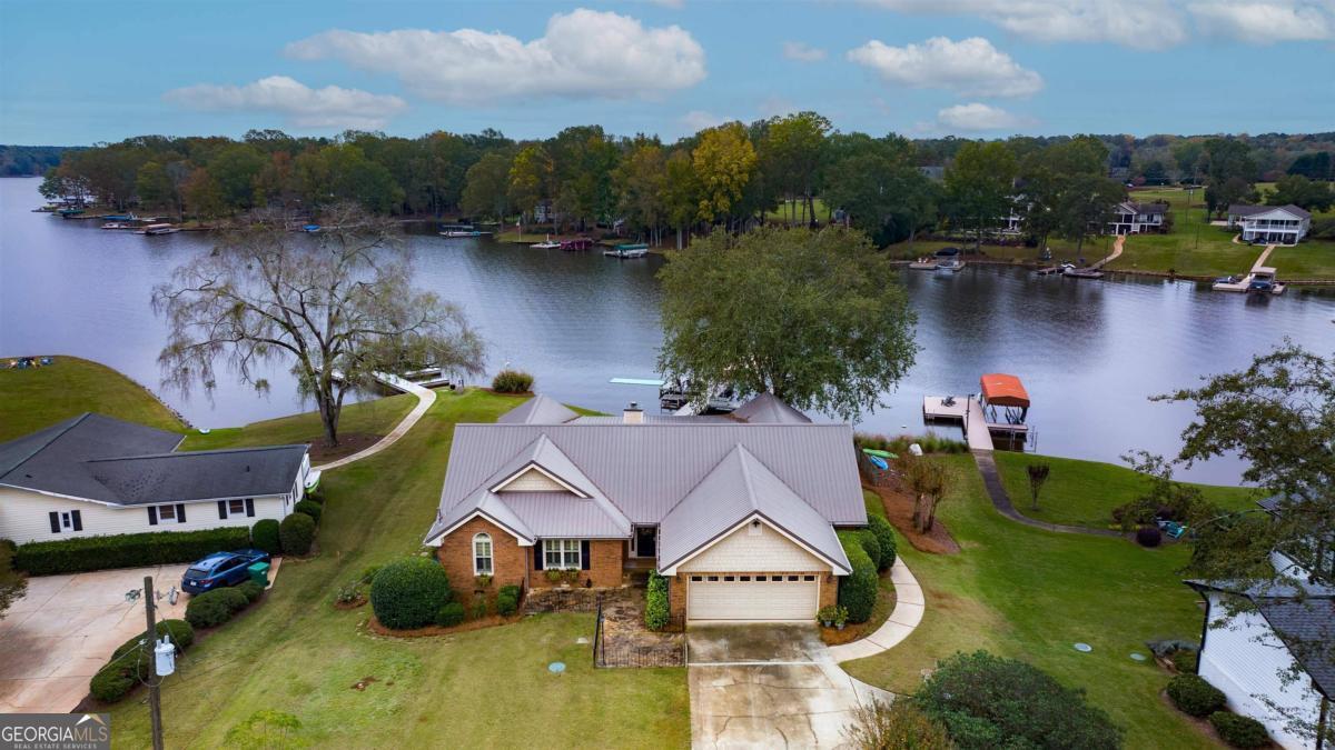 an aerial view of a house with swimming pool and lake view