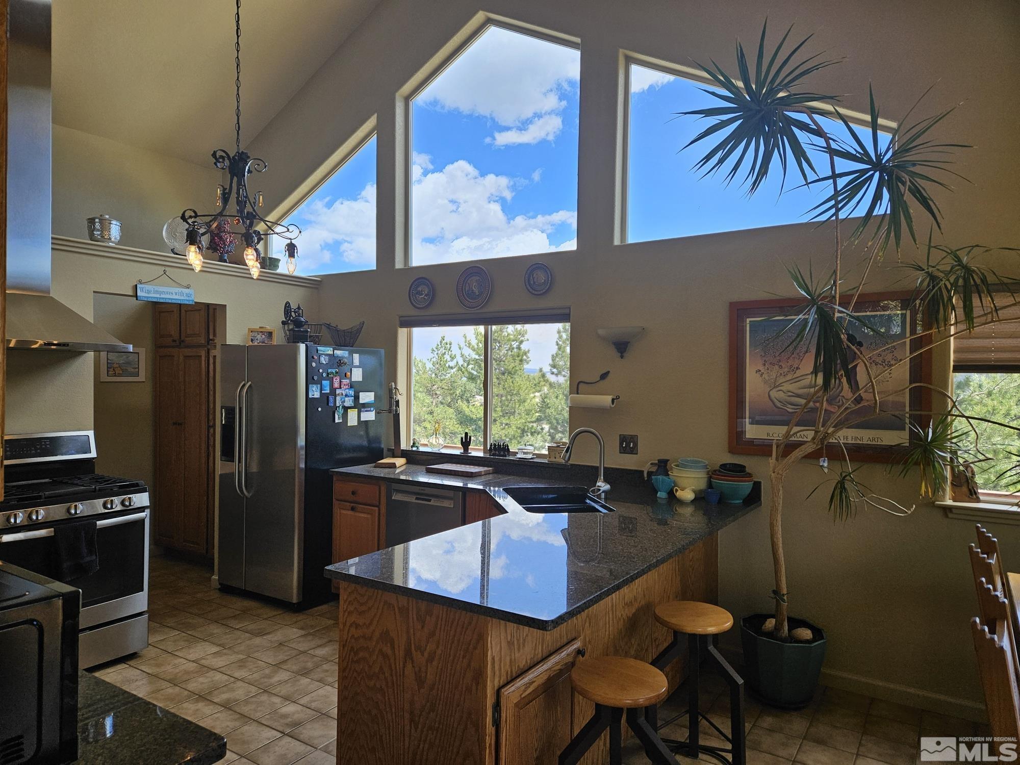 a kitchen with stainless steel appliances granite countertop a sink a stove and refrigerator