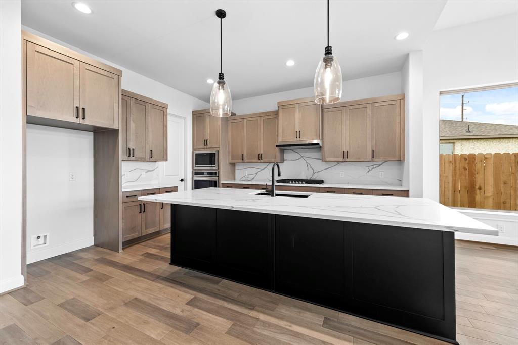 a kitchen with kitchen island a sink stainless steel appliances and cabinets