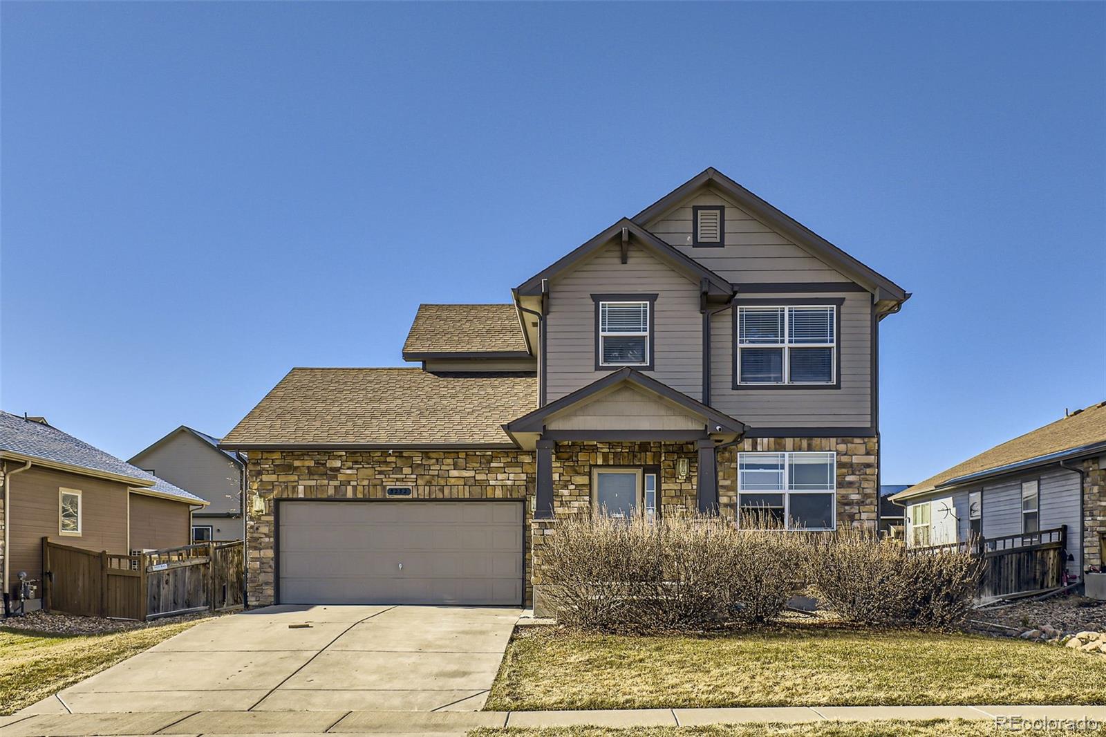 a front view of a house with yard and parking