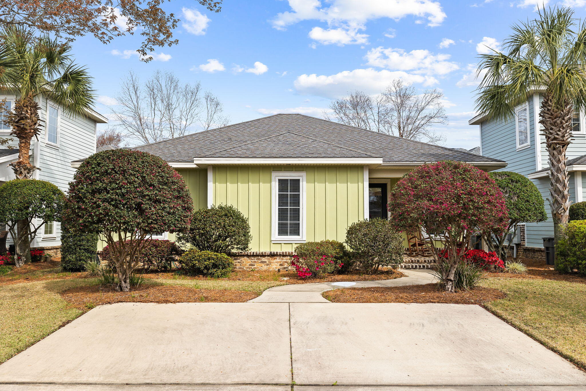 a front view of a house with a yard and tree s