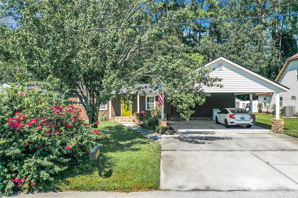 a view of a house with a patio and a yard