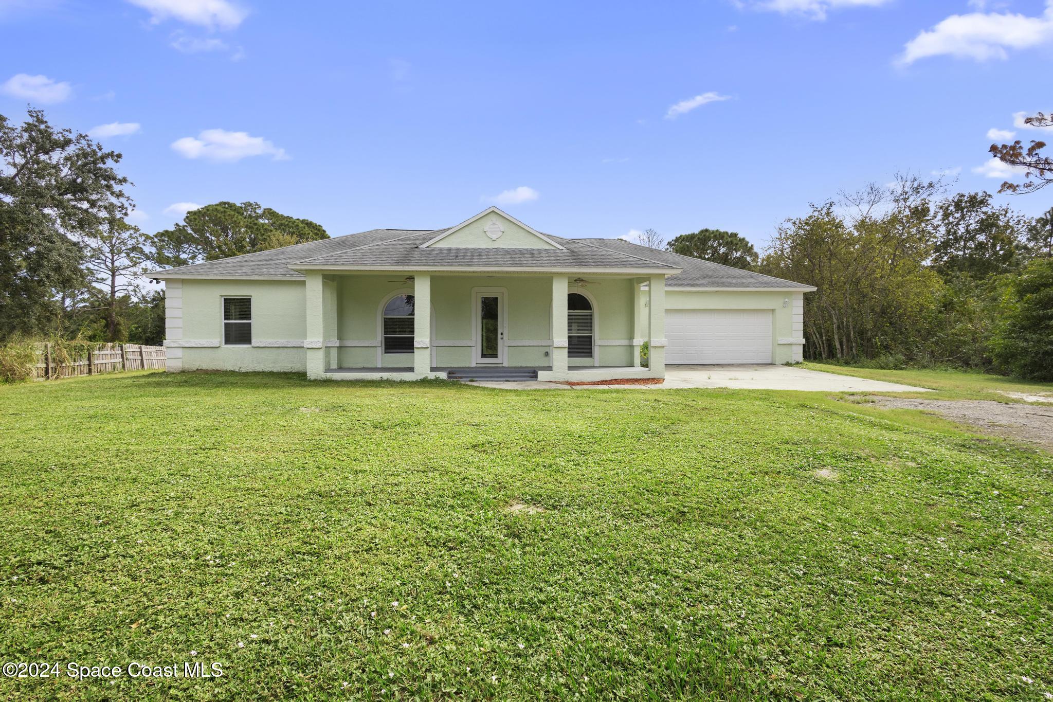 a front view of a house with a garden and yard