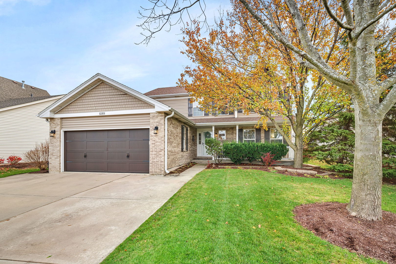 a front view of a house with a yard and garage