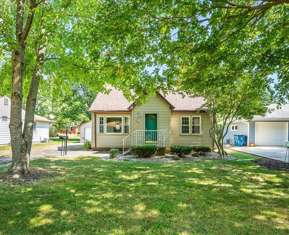 a front view of a house with a yard and trees