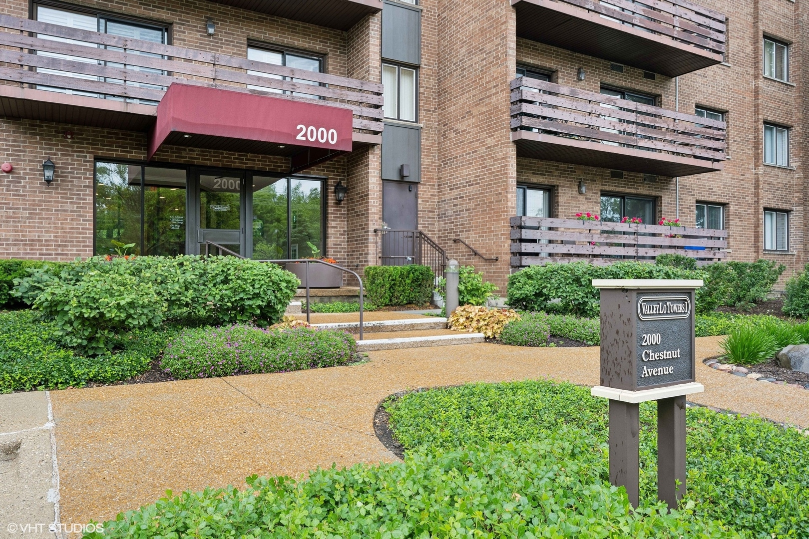 a front view of a building with a garden and plants