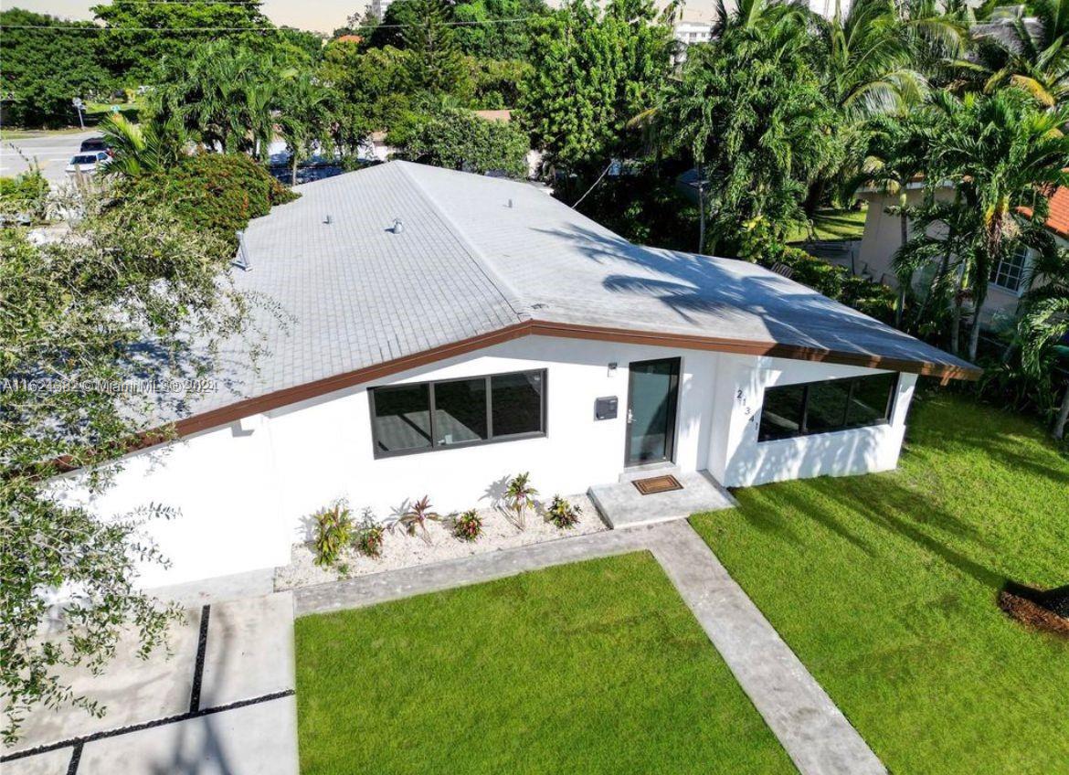 a aerial view of a house with table and chairs under an umbrella