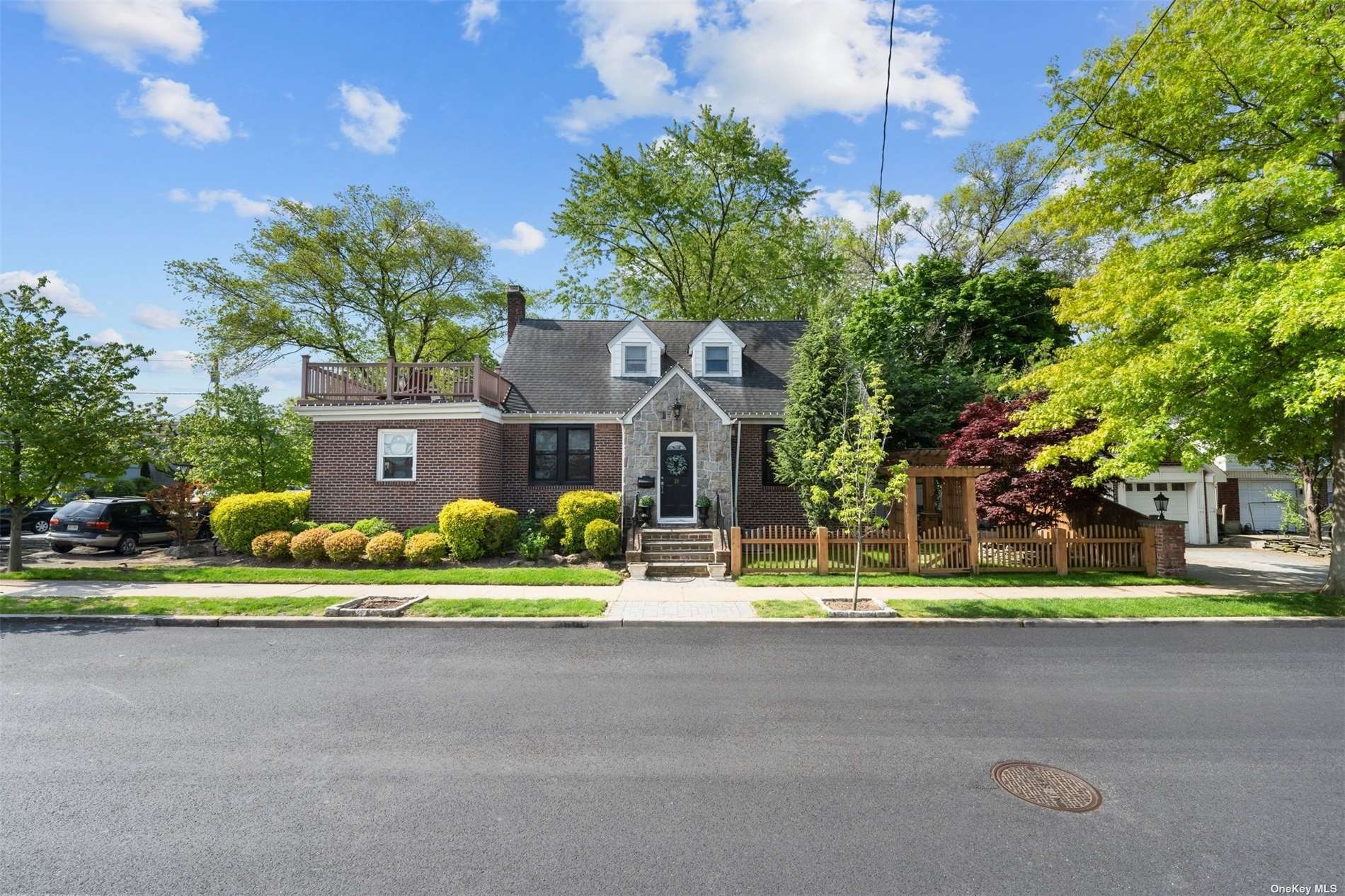 a front view of a house with a garden and tree