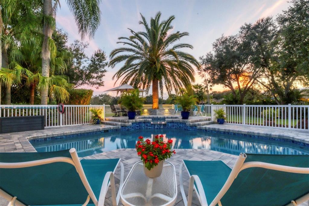 a balcony with table and chairs potted plants