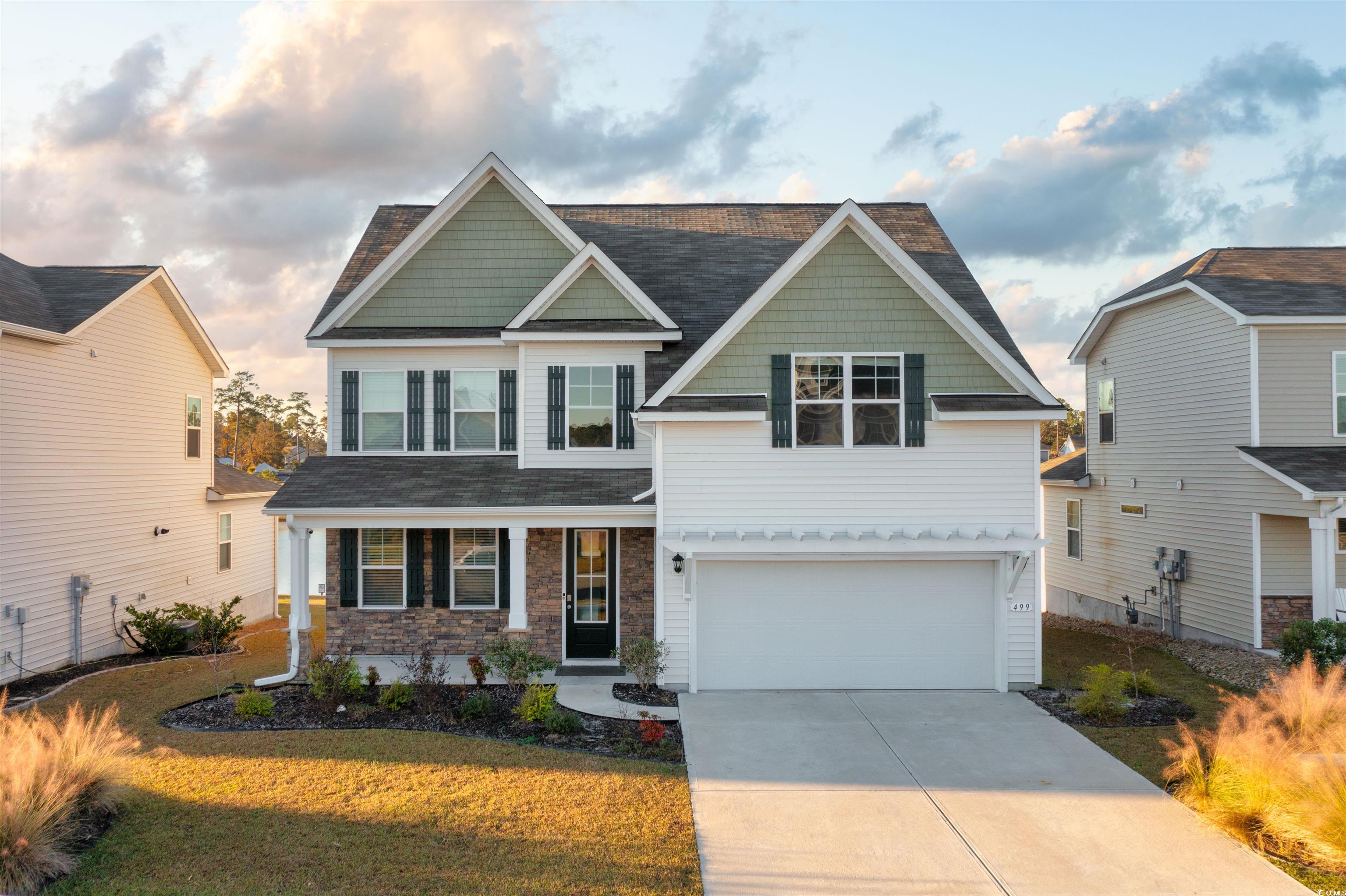 Craftsman inspired home with a front yard and a ga