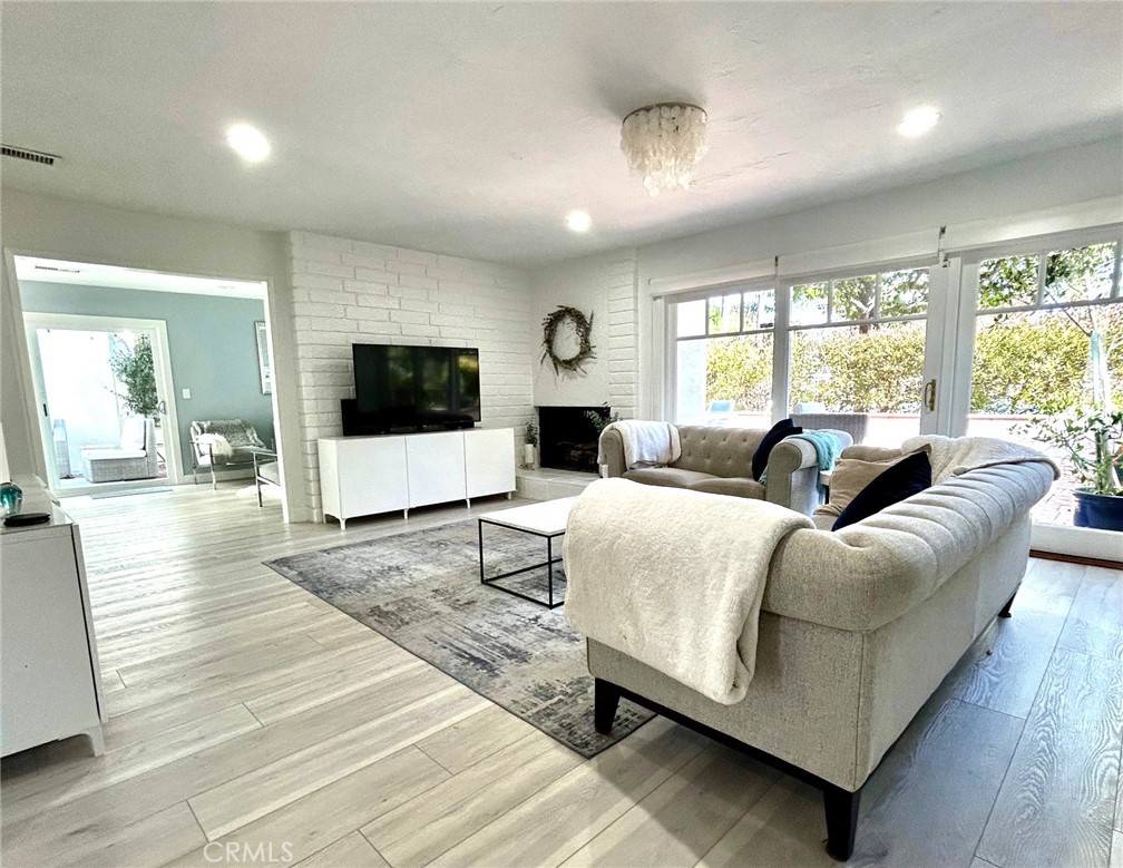 a living room with furniture flat screen tv and a large window