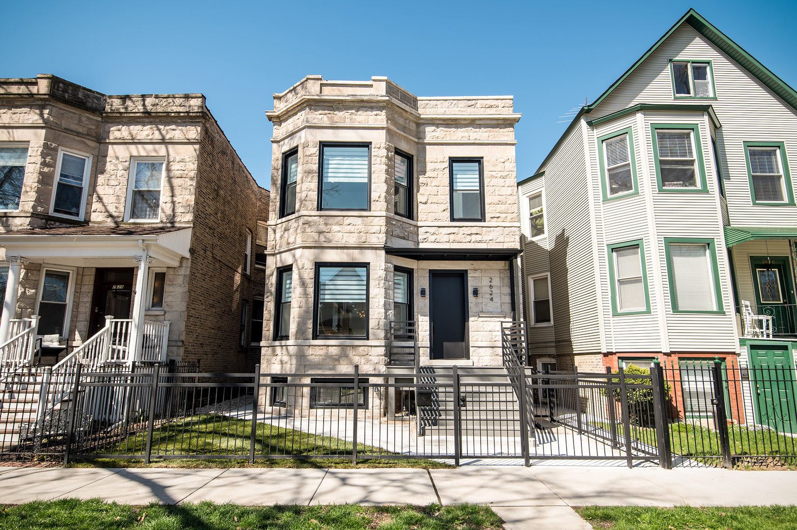 a front view of a residential apartment building with a yard