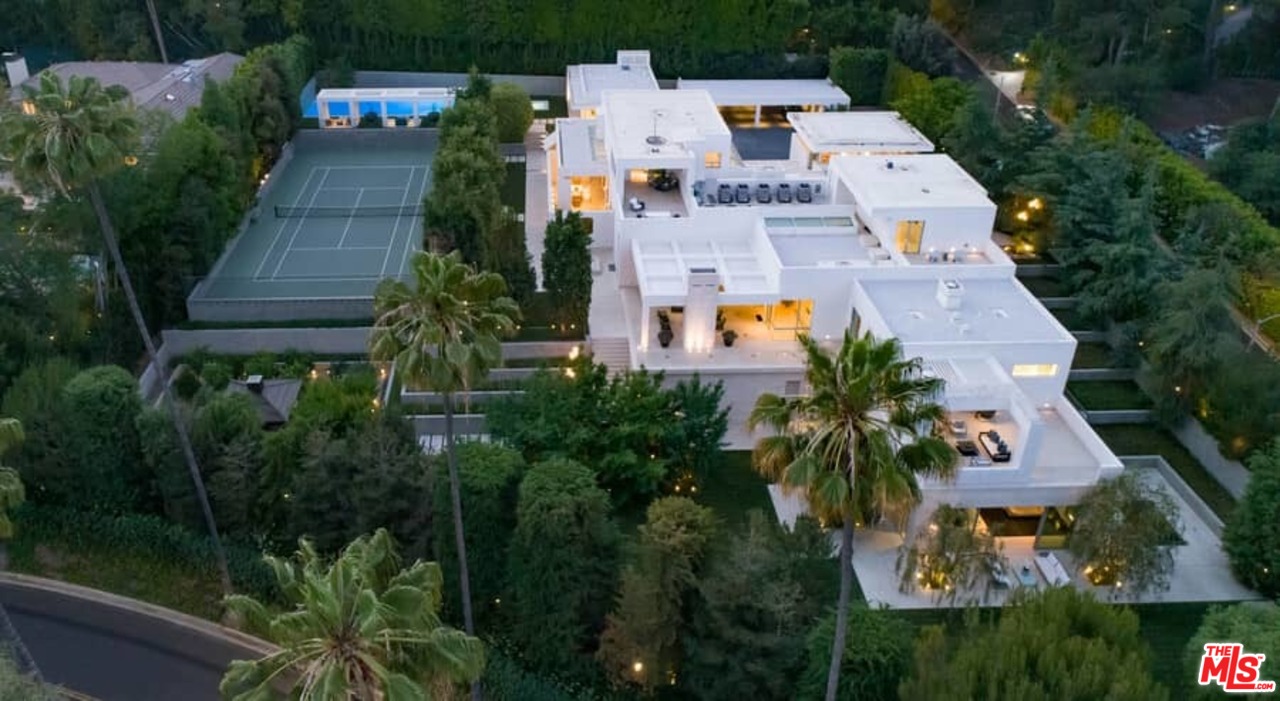 an aerial view of residential house with outdoor space and trees all around