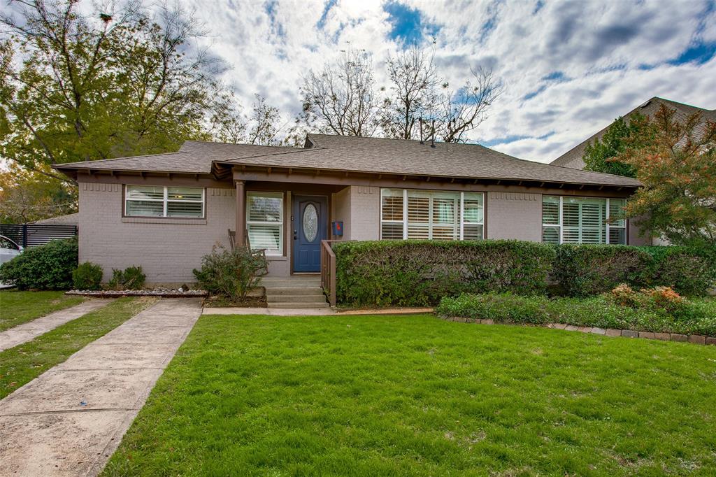 a front view of a house with yard and green space