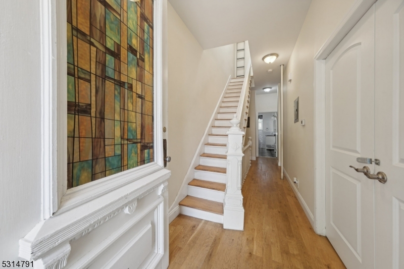 a view of a hallway with wooden floor and windows