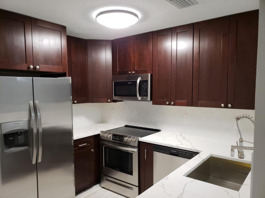 a kitchen with stainless steel appliances granite countertop a sink and a refrigerator