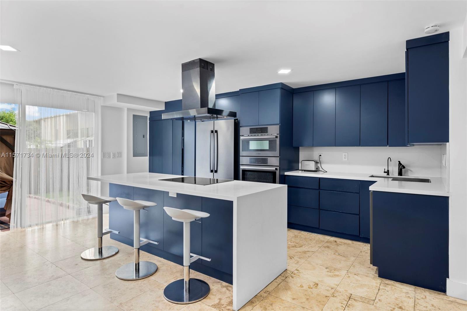 a kitchen with kitchen island granite countertop a sink stove and cabinets