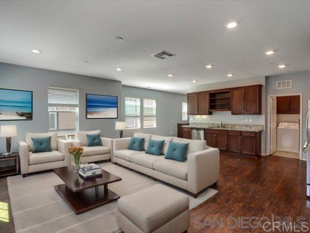 a living room with furniture and view of kitchen