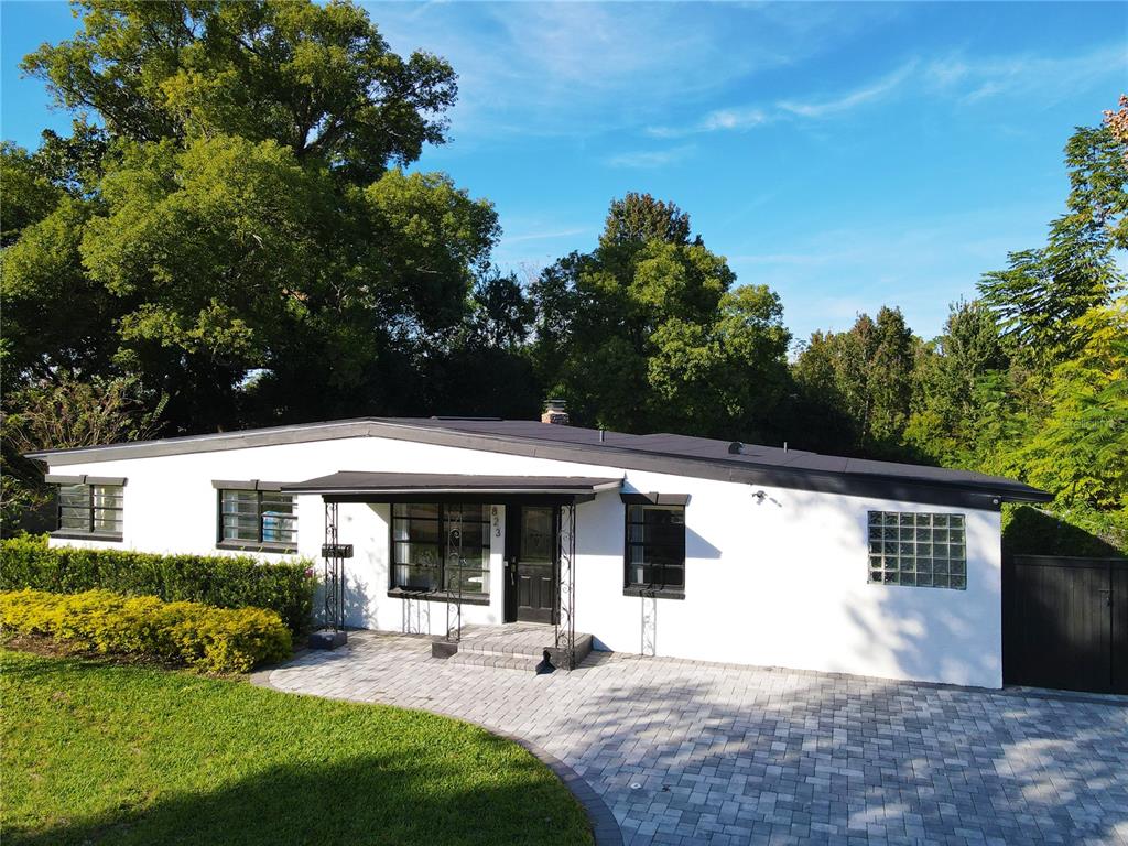 a view of house with backyard and sitting area