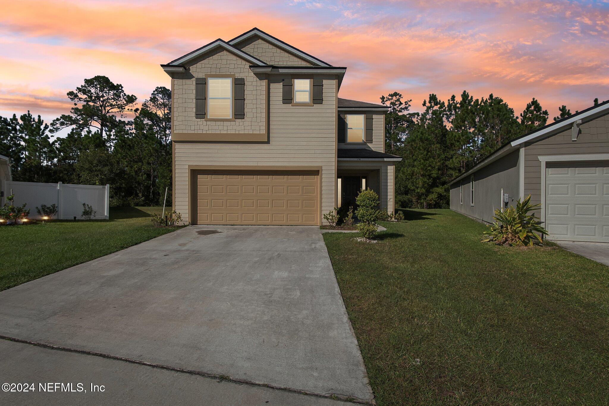 a front view of a house with a yard and garage