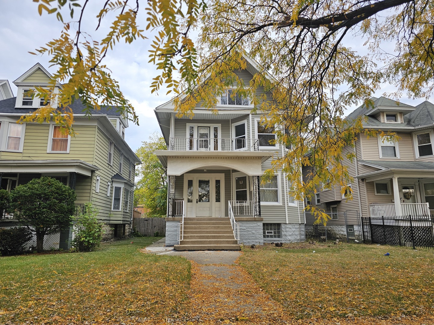 a front view of a house with a garden and tree