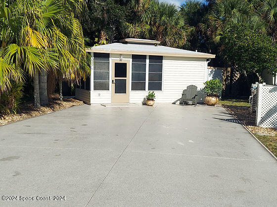 a view of a house with a patio and a yard