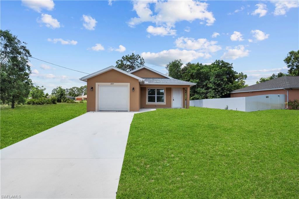 Ranch-style house with a garage and a front lawn