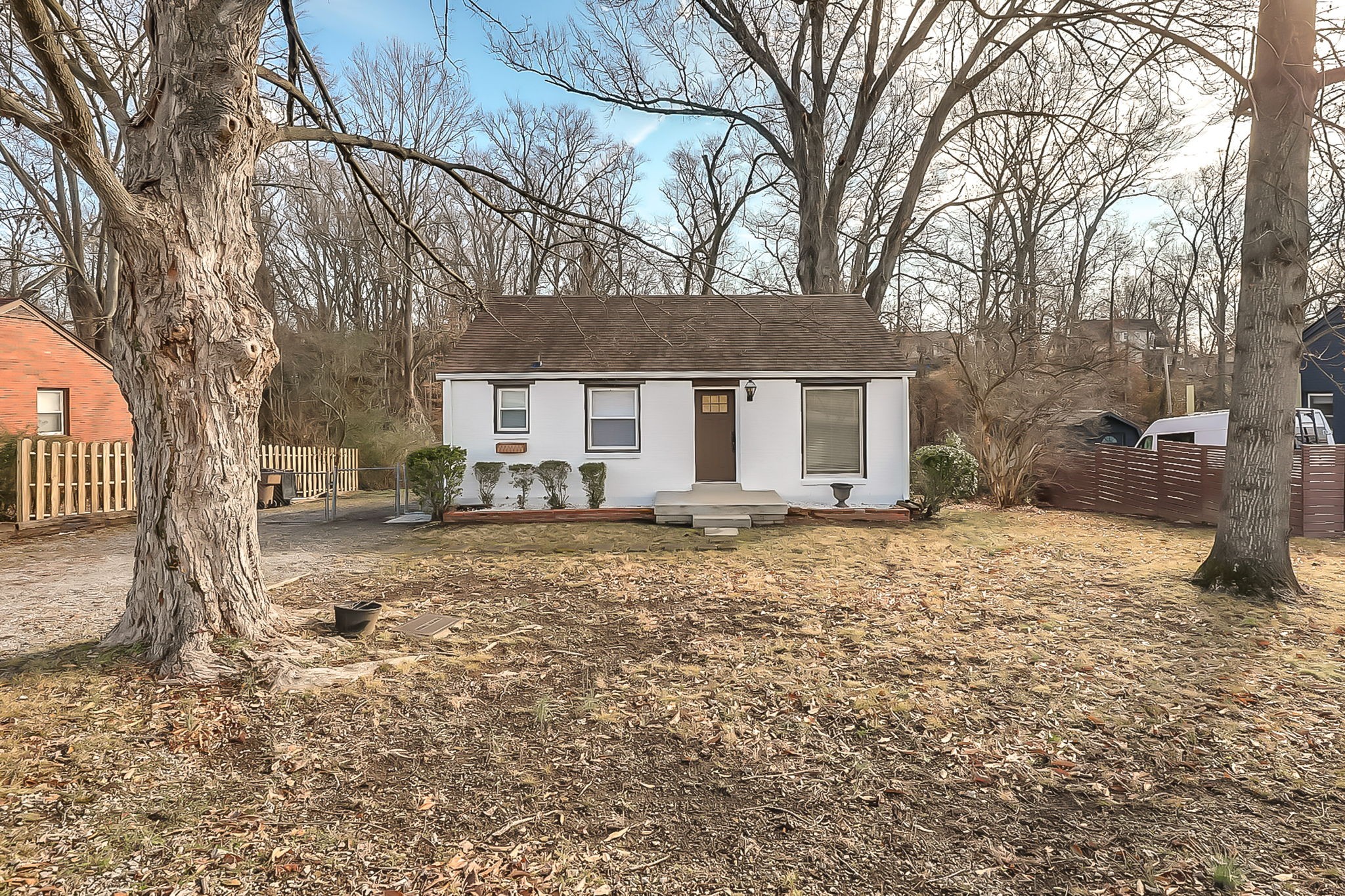 a yard with a tree in front of the house