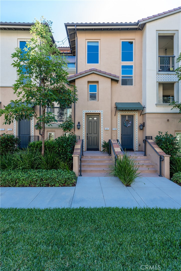 a front view of a house with a yard and potted plants