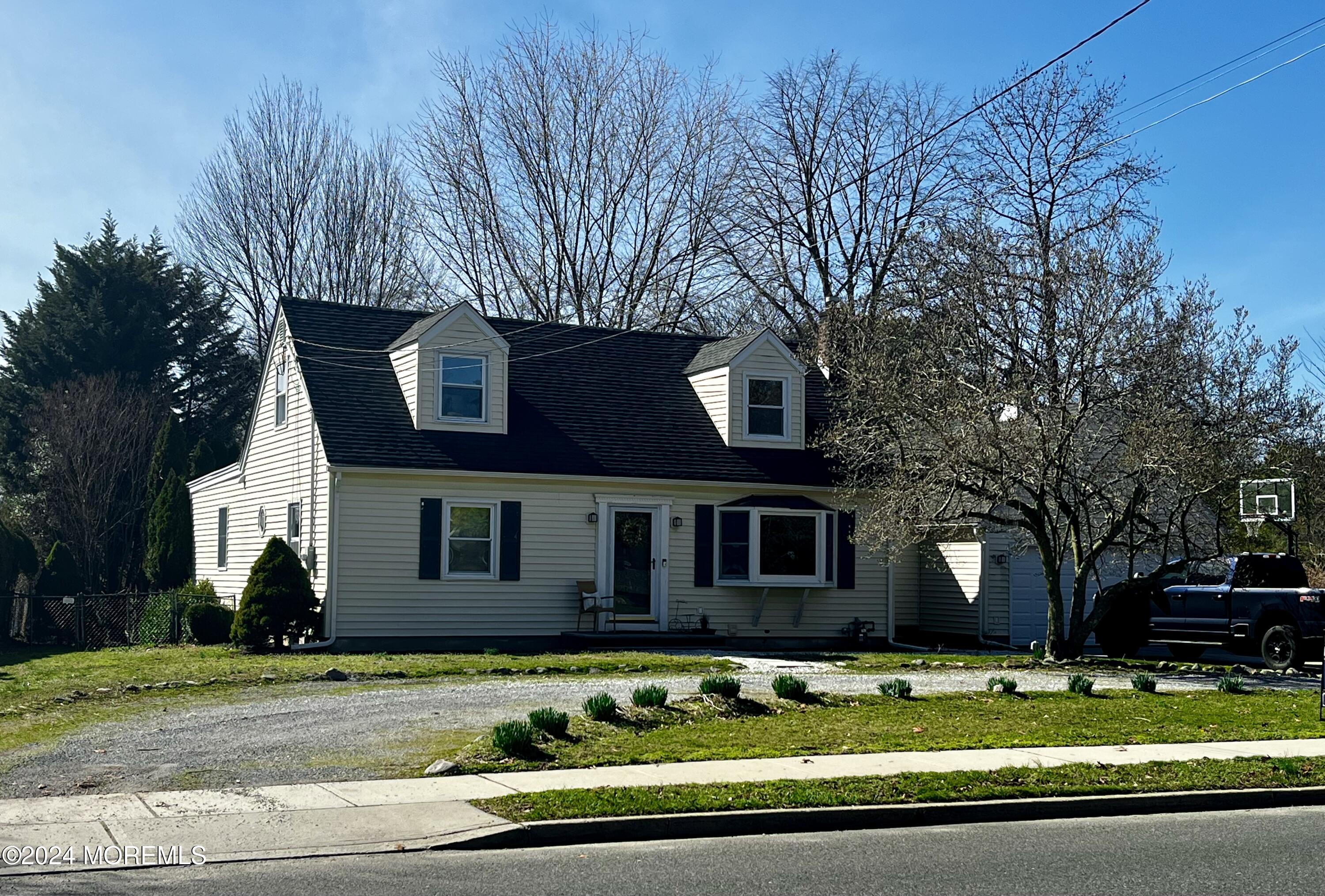 a view of a house with a big yard and large trees