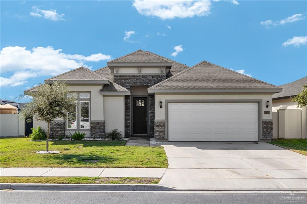 a front view of a house with a yard and garage