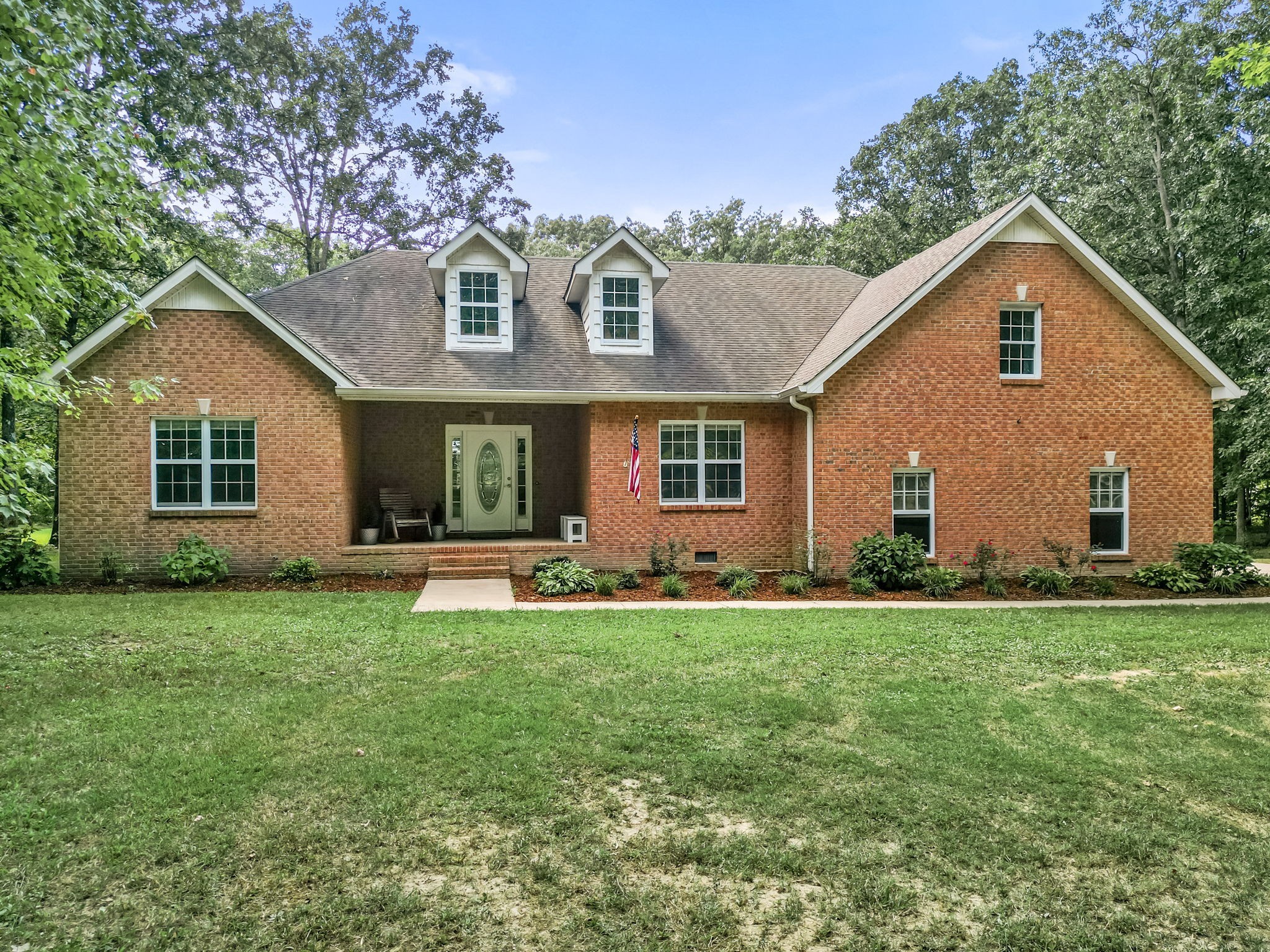 a front view of a house with a yard and porch