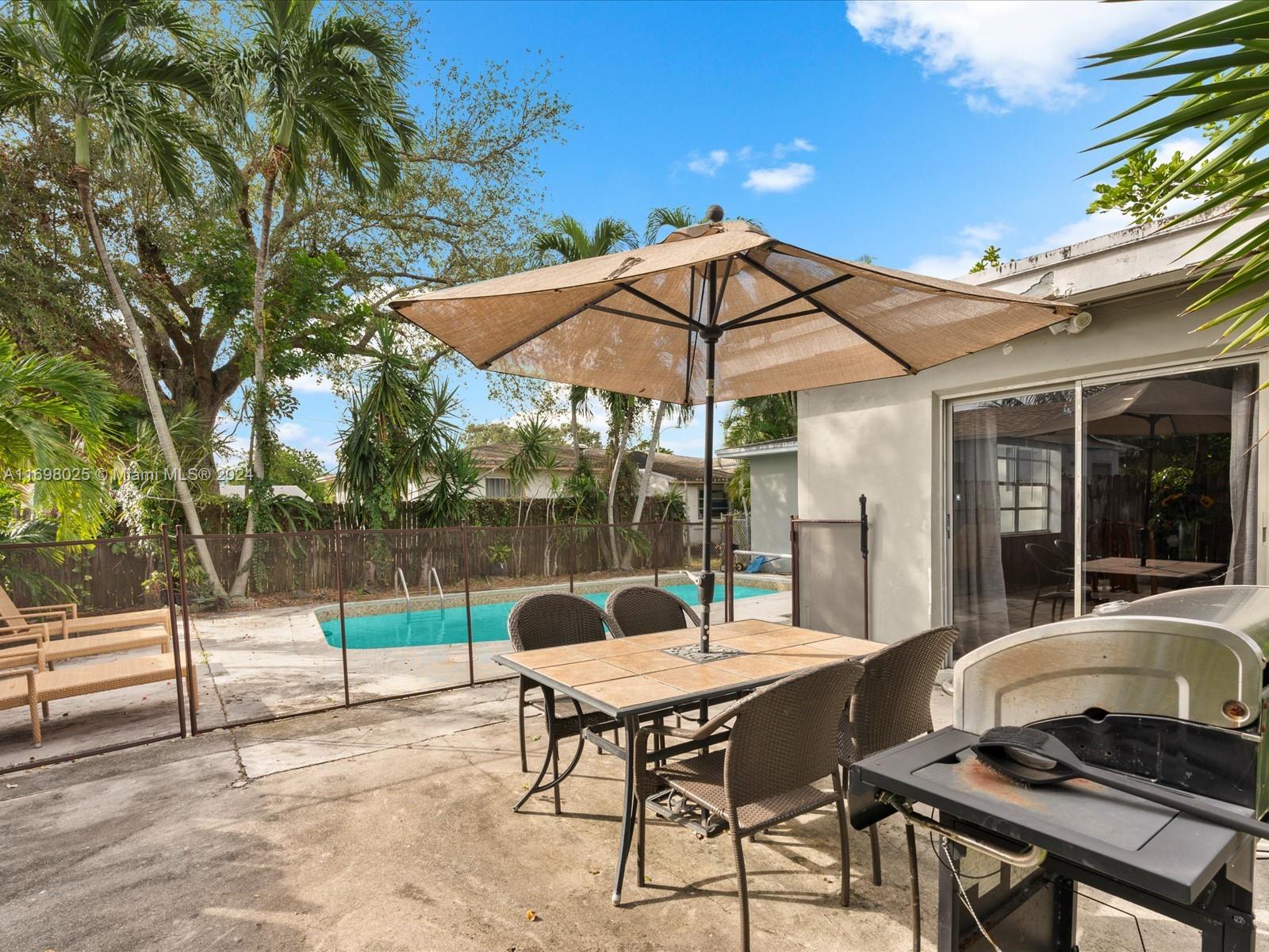 a patio with a table and chairs under an umbrella