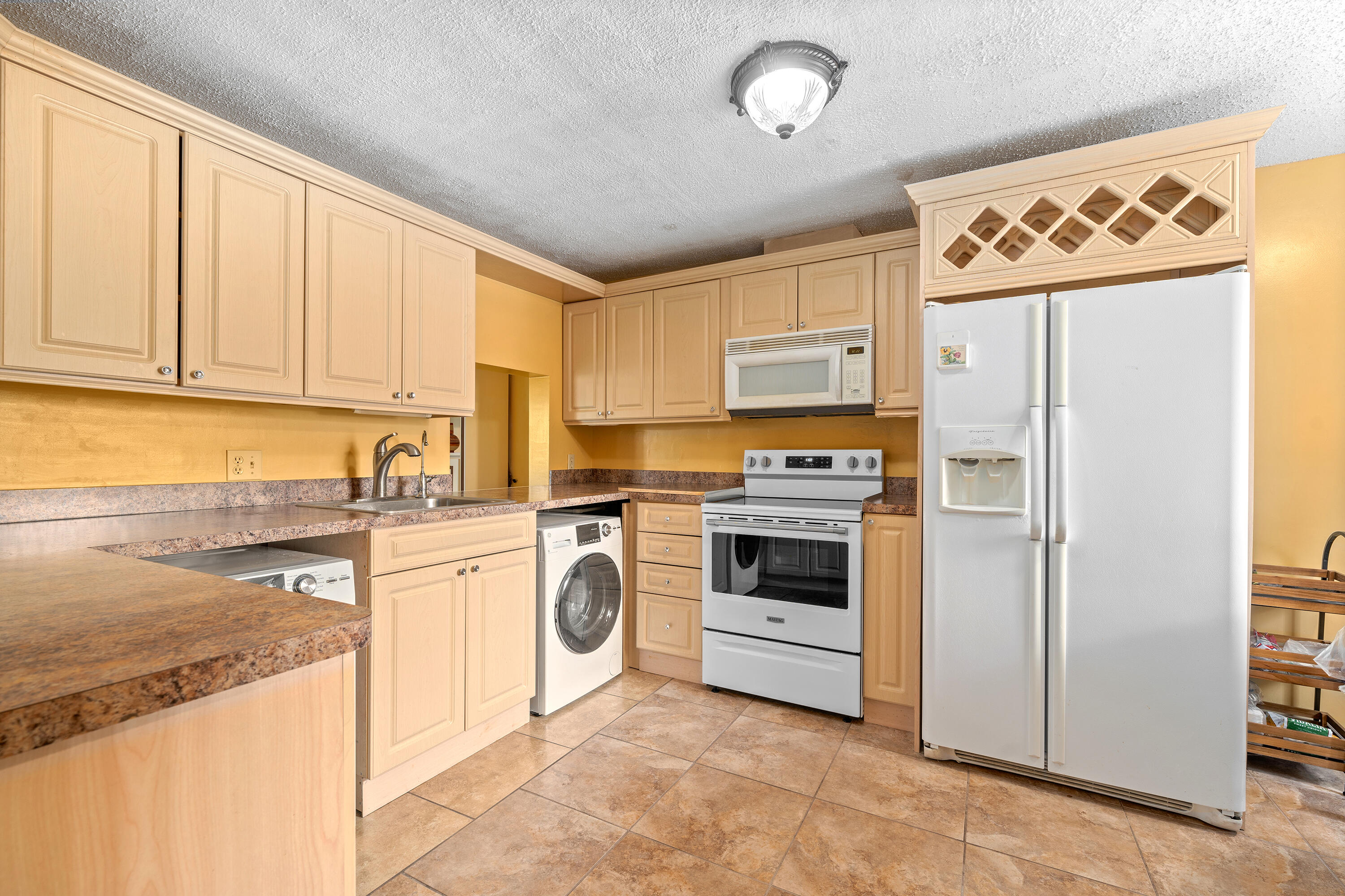 a kitchen with a stove top oven sink and refrigerator