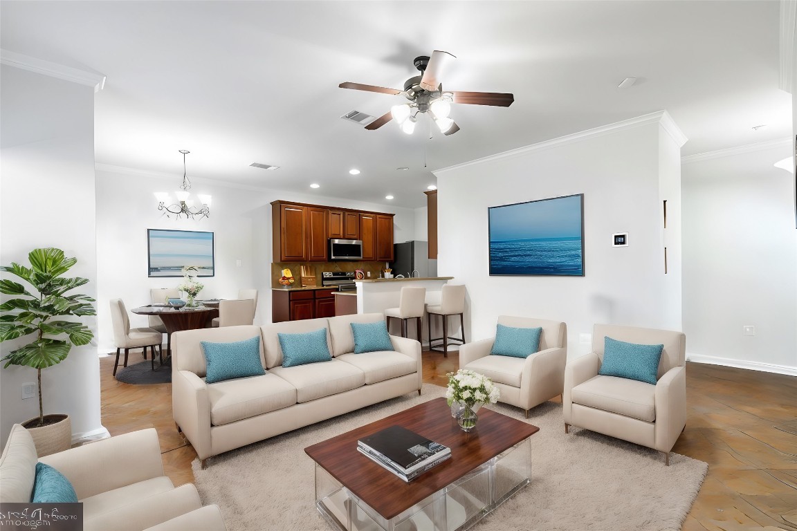 a living room with furniture kitchen view and a chandelier