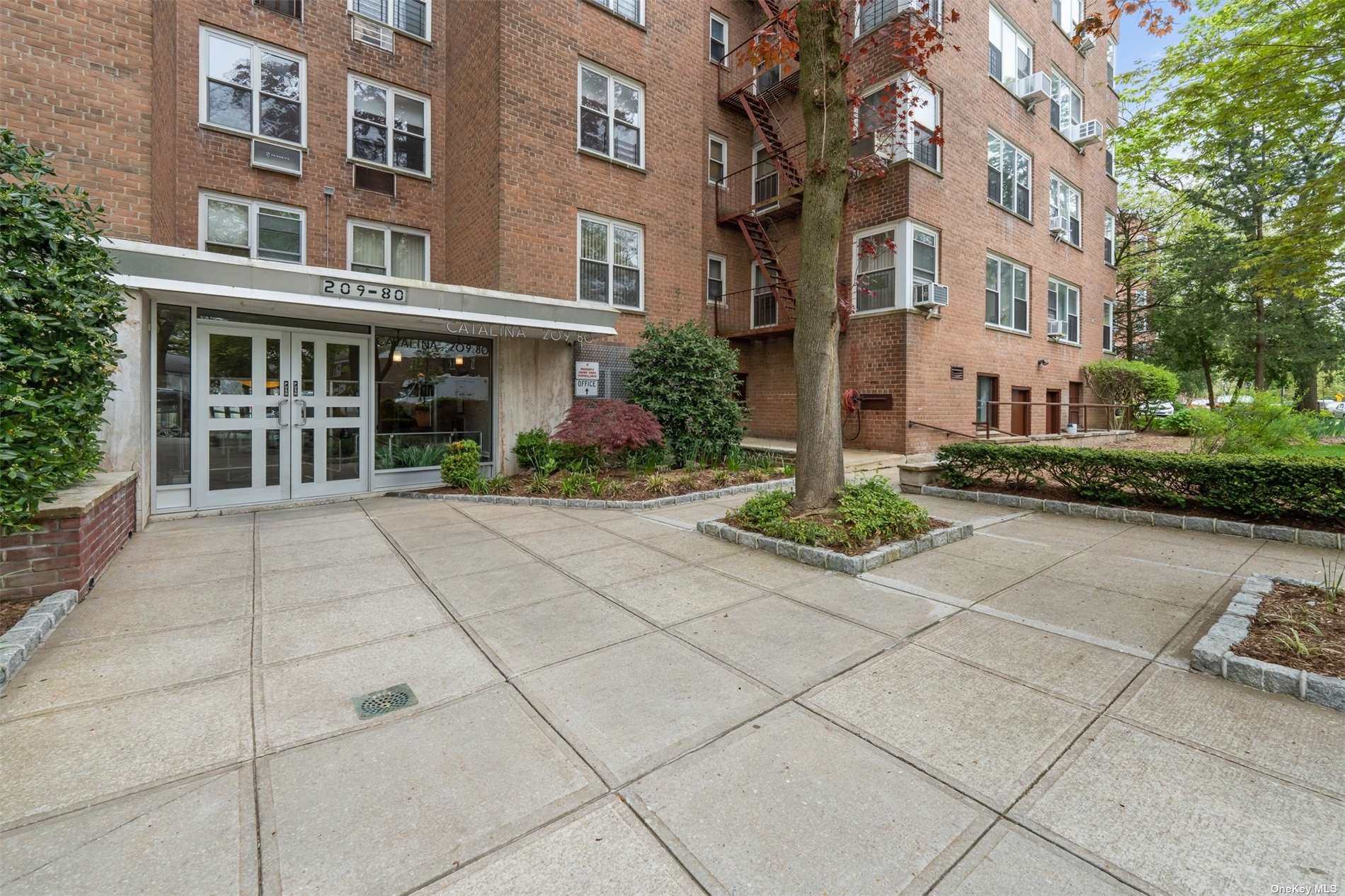 a view of a building with a bench and trees around