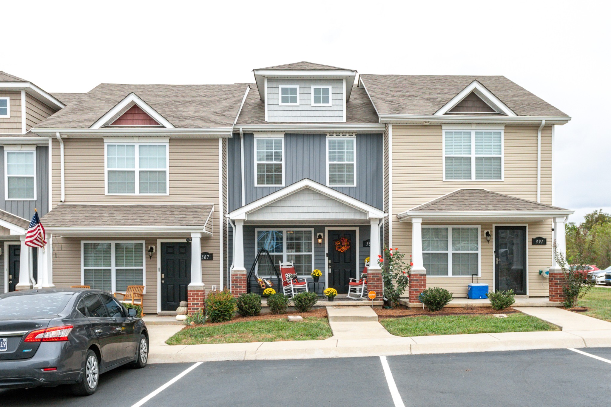 a front view of a residential apartment building with yard and green space