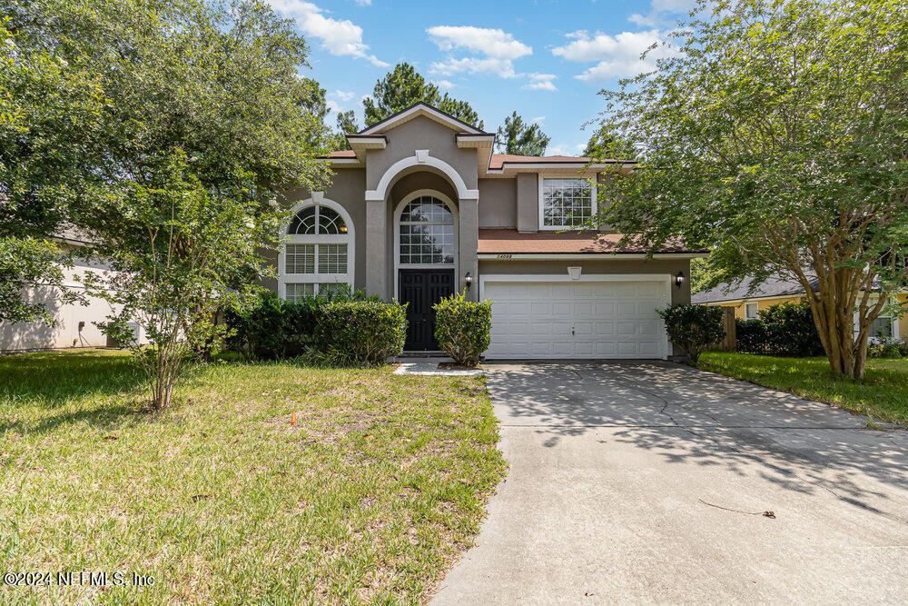 a front view of a house with a yard and garage