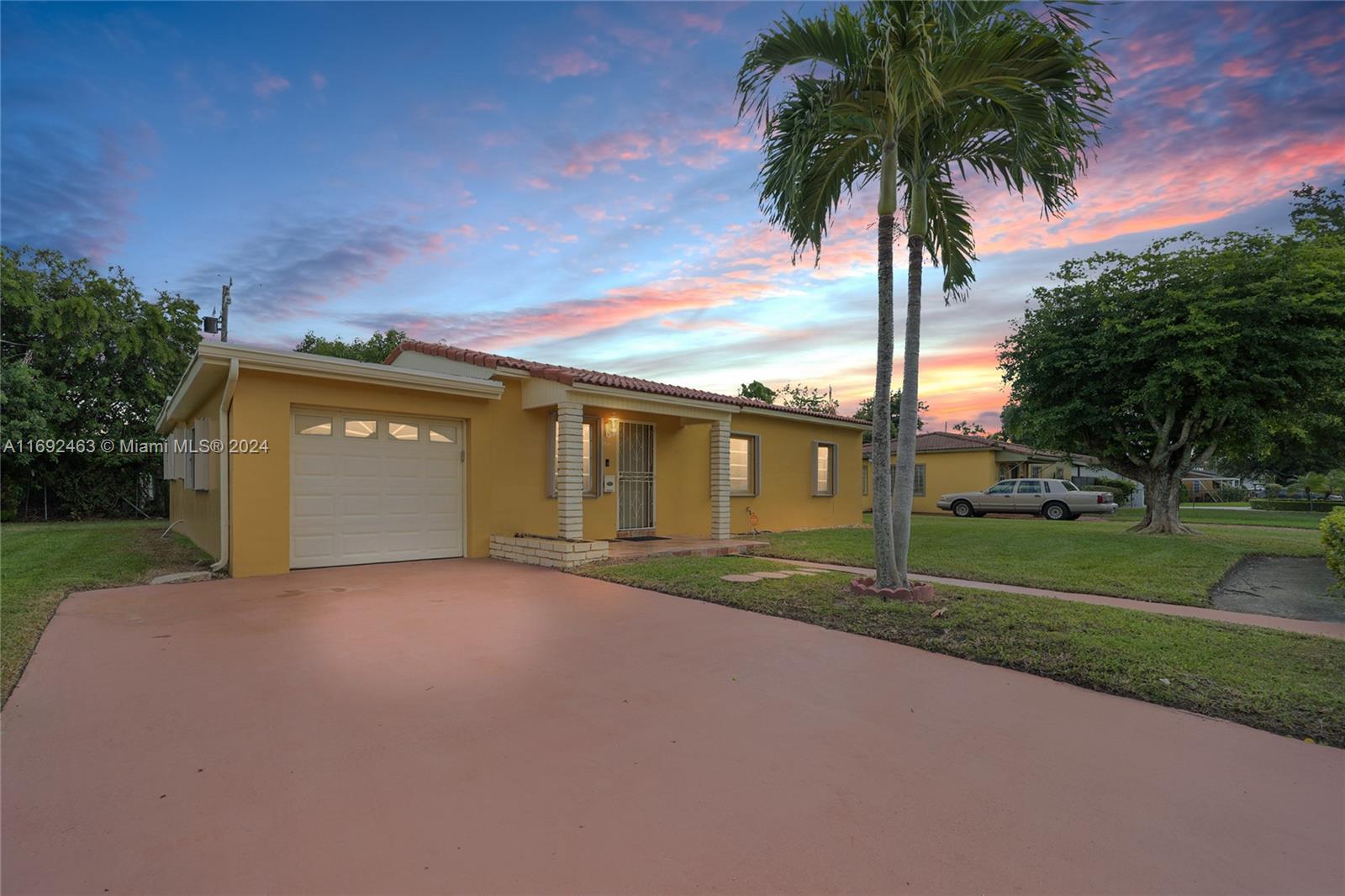 a view of a house with a yard and palm trees