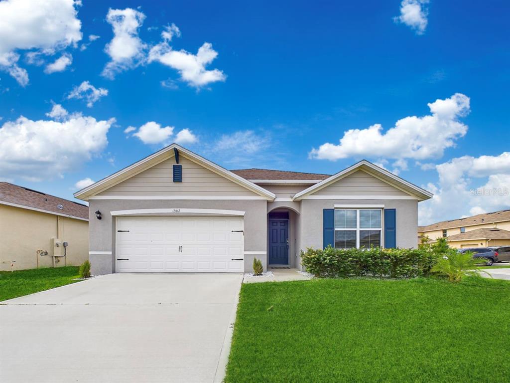 a front view of a house with a yard and garage