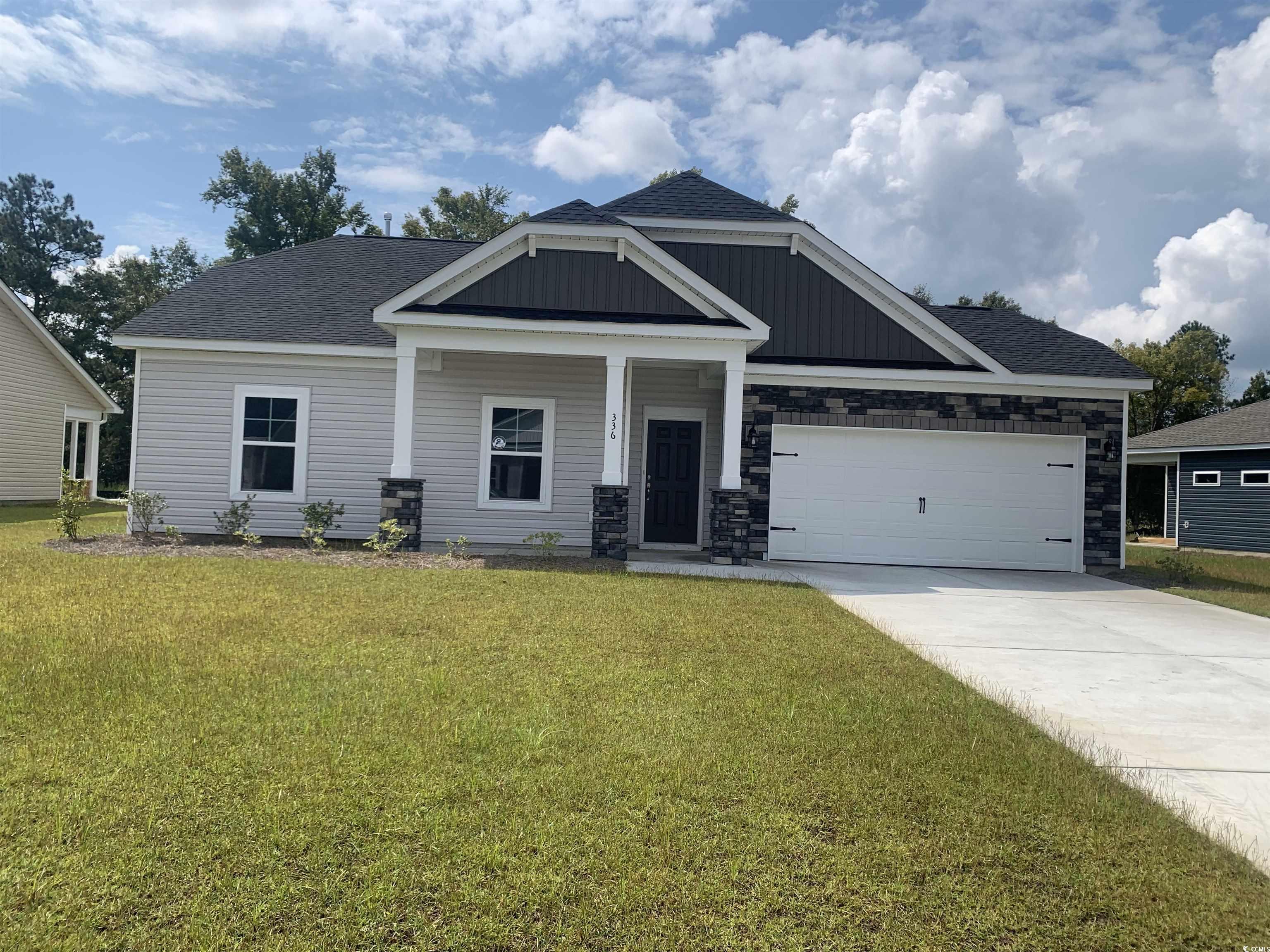 Craftsman-style home with a front lawn, covered po