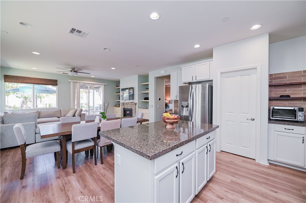 a kitchen with stainless steel appliances granite countertop a kitchen island hardwood floor and a sink