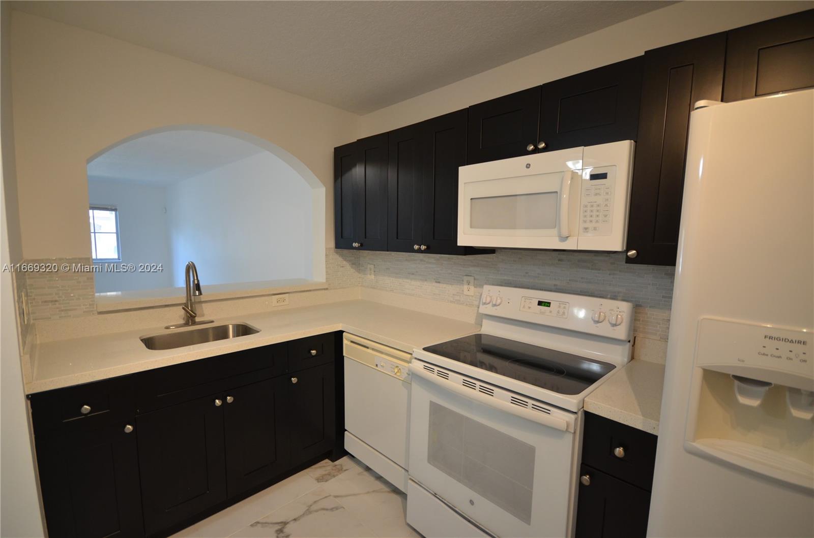 a kitchen with a sink and a stove top oven