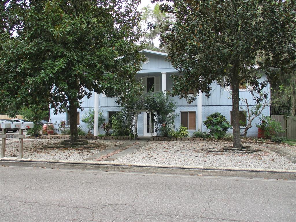 a front view of a house with garage and plants