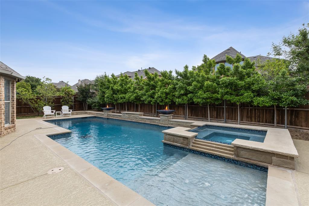 a view of swimming pool with chairs in back yard