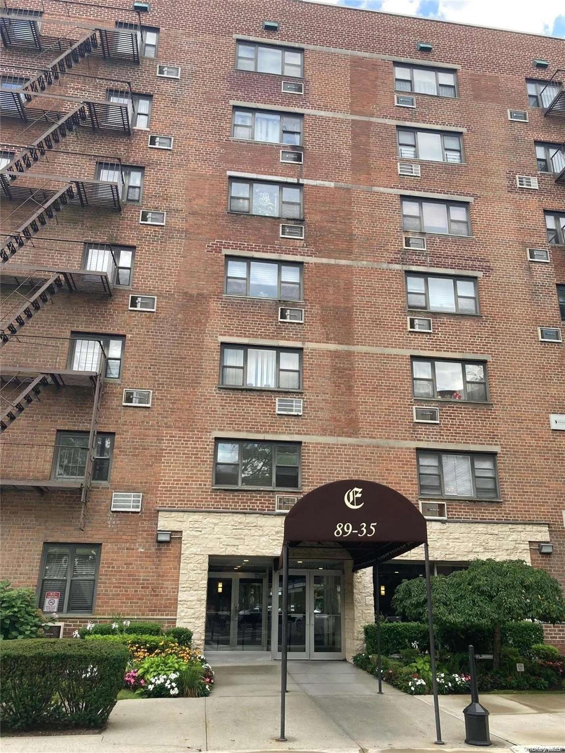 a front view of a building with a garden