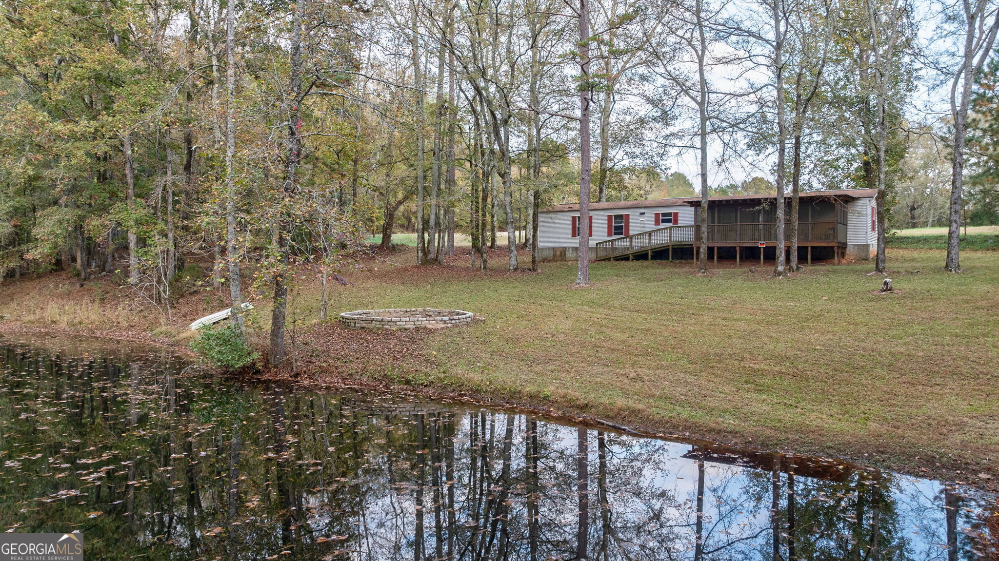 a view of a lake with a house and a forest