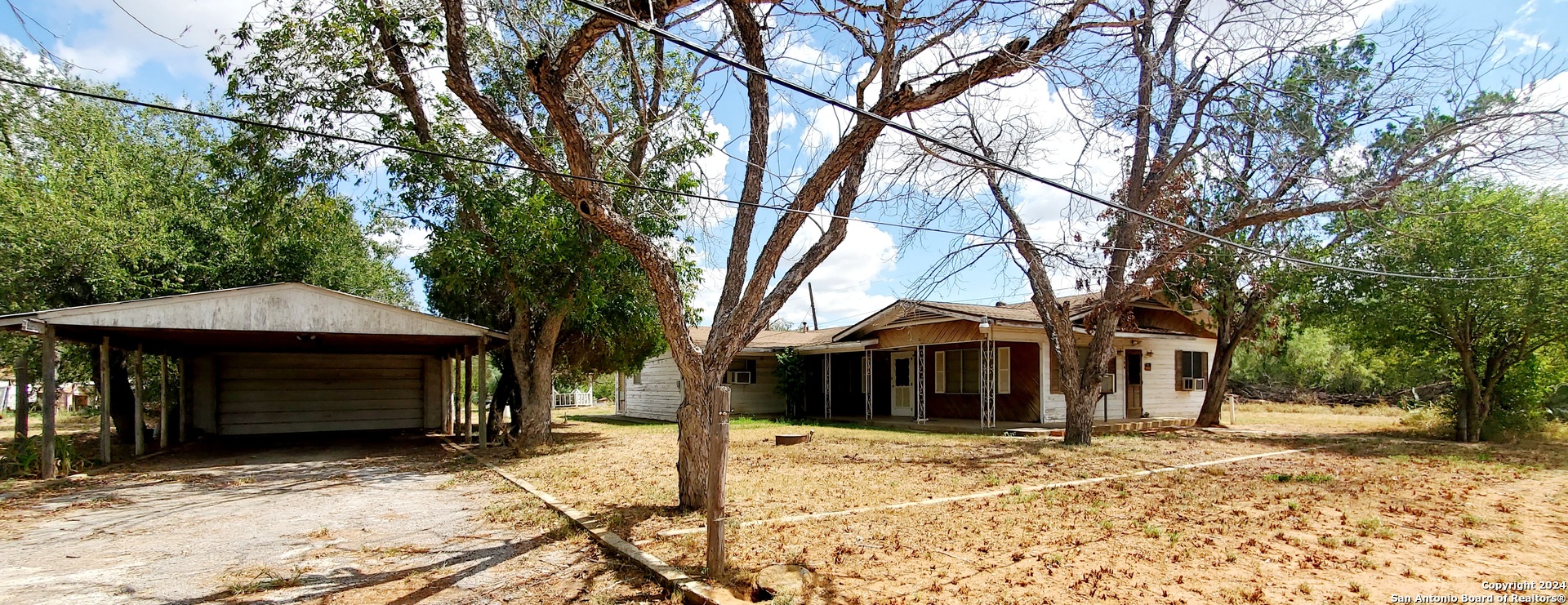 a front view of a house with a yard and trees