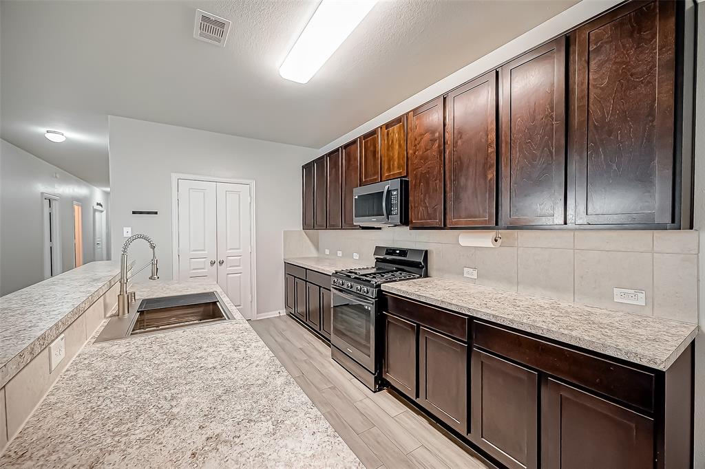 a kitchen with a sink stove and refrigerator