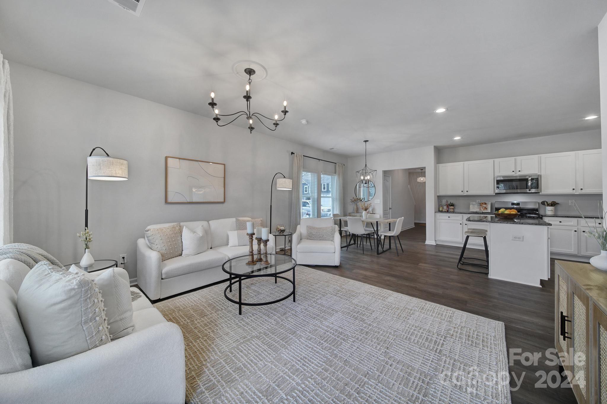 a living room with furniture and kitchen view